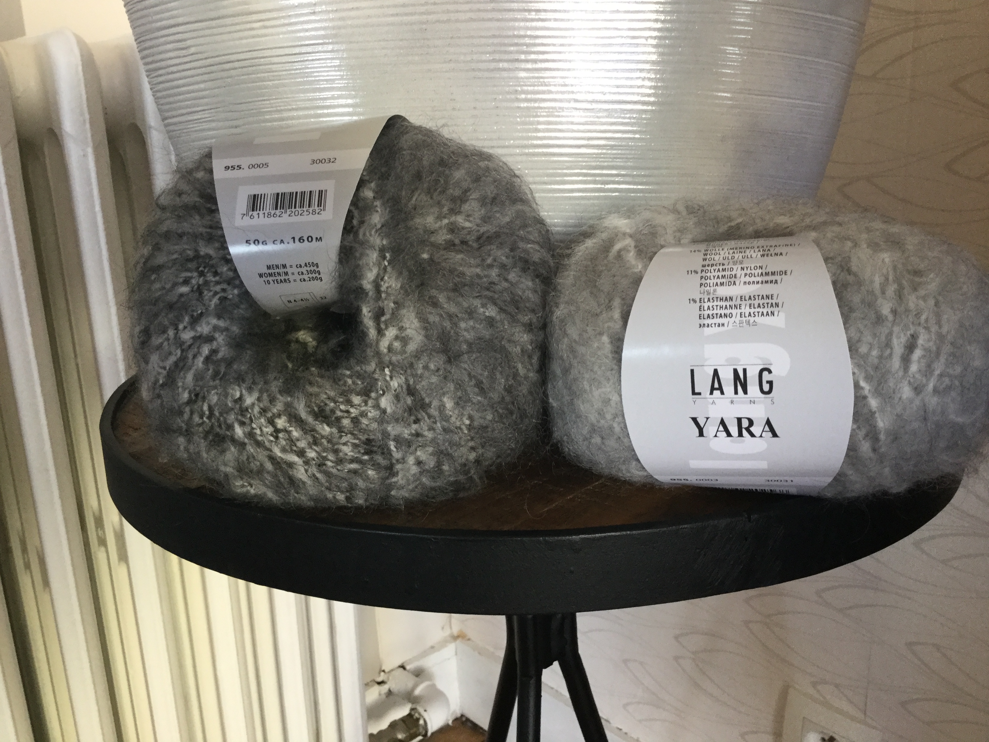 Two balls of fuzzy yarn in shades of grey.